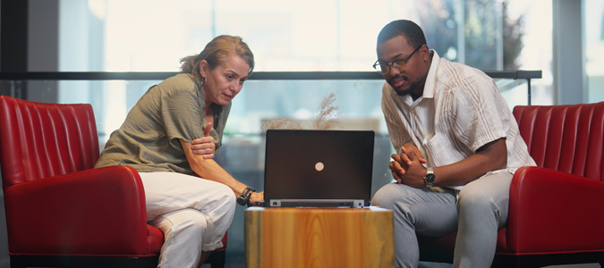 Two colleagues discussing options on a laptop