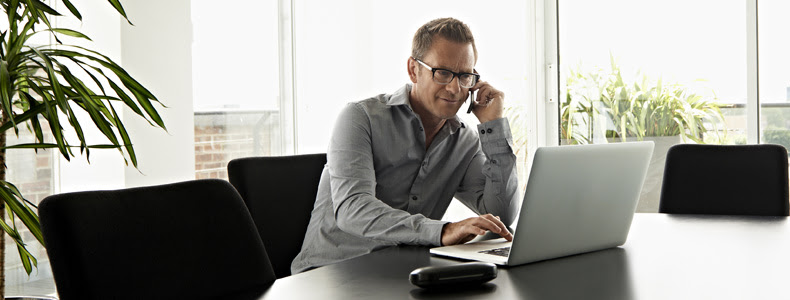 person talking on cell while on computer