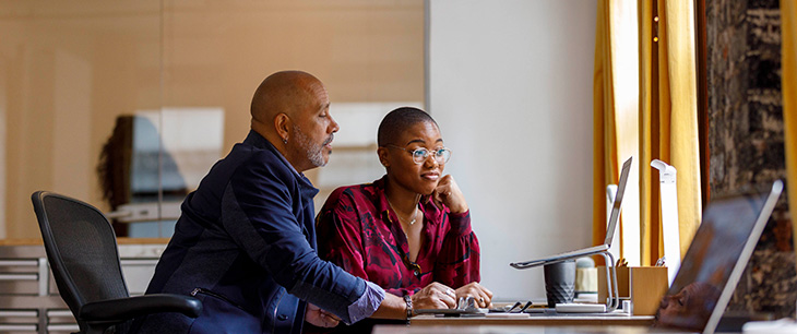 Two colleagues sitting side by side in a modern office