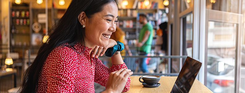 South pacific business woman smiling and looking at a laptop