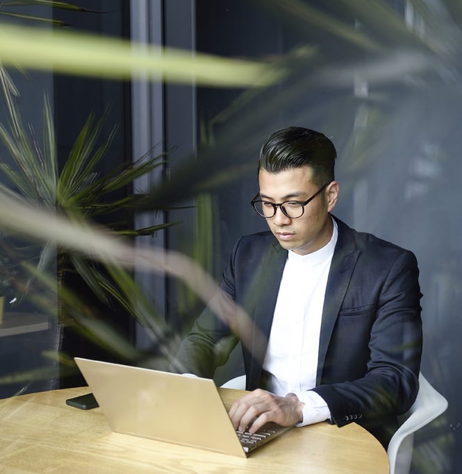 Business person sitting at table on their laptop