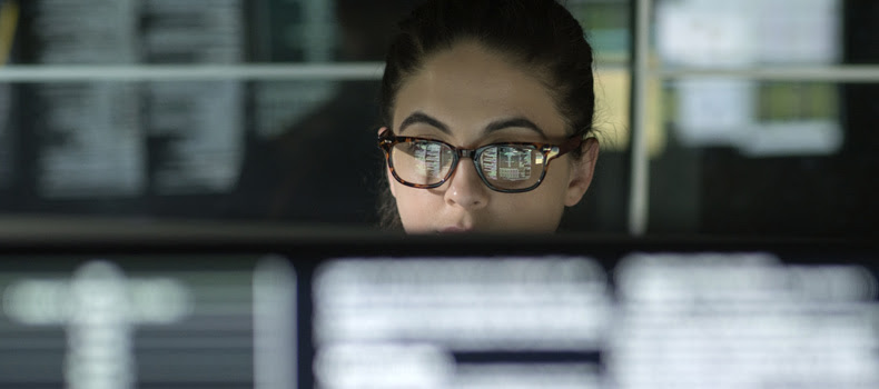 dark image of person looking at code on computer