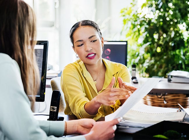 Group of young modern people in smart casual wear discussing business while sitting in the creative office