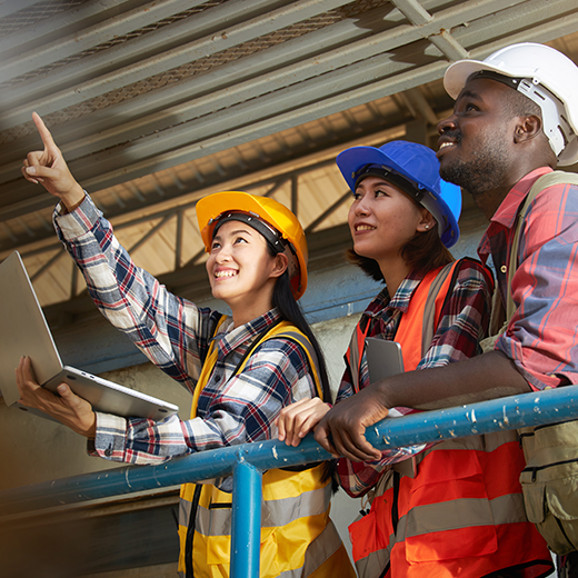 A group of ethnically diverse engineers inside an industrial plant.