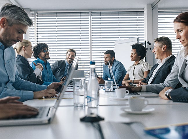 Grand conseil d’administration réuni autour d’une table de conférence dans un bureau.