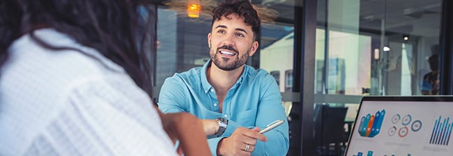 person talking to someone with charts on their laptop screen