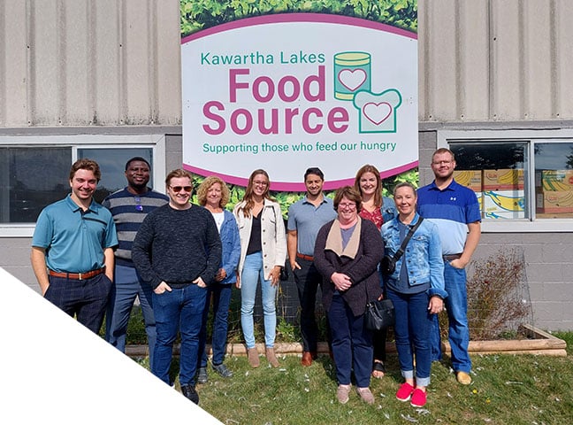 A group of BDO employees in front of a sign that reads “Kawartha Lakes, Food Source, Supporting those who feed our hungry.”