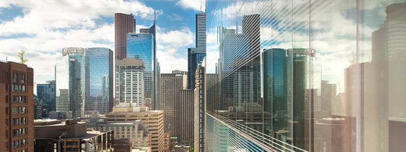 L’horizon du centre-ville se reflète sur la fenêtre en verre d’une tour à bureaux.
