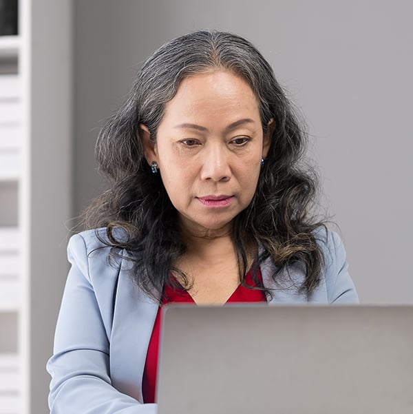 A businesswoman working on a laptop in a modern office