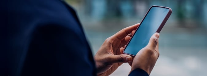 Gros plan sur une main tenant un téléphone intelligent.