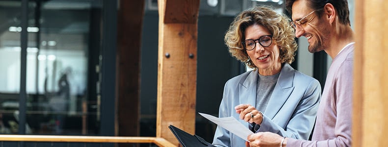 two people looking at paper talking