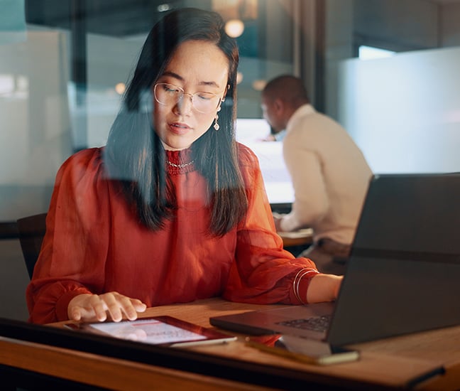 Femme travaillant sur un ordinateur portable et une tablette