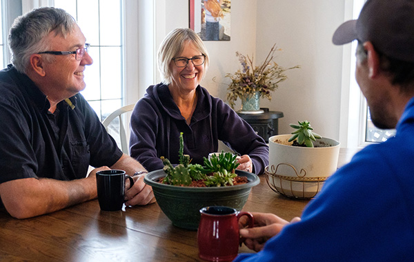 family of farmers sitting at dinner table drinking coffee