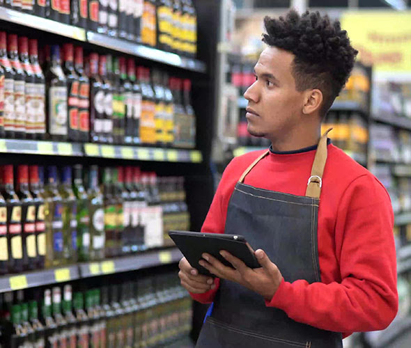 Employee checking tablet in grocery store