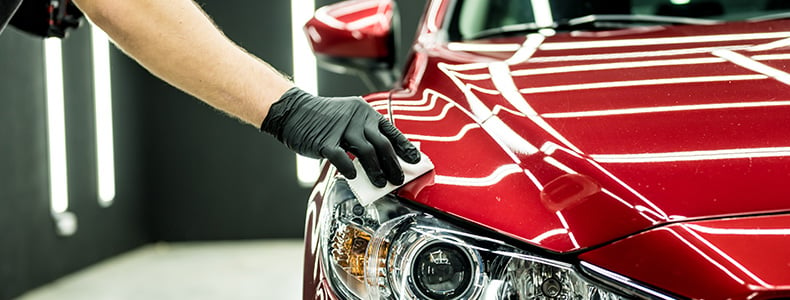 person detailing a red car