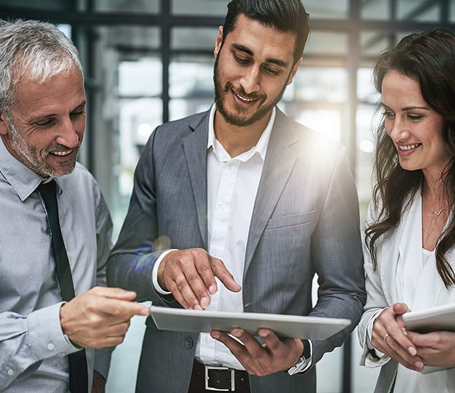 People at work gathered around a tablet