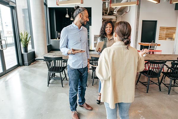 group of three people talking