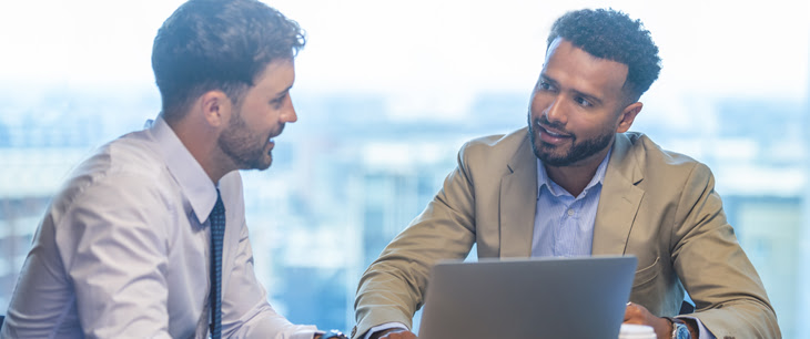 2 people discussing with computer